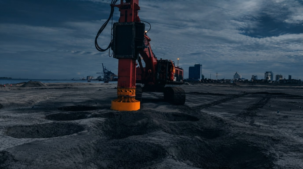 Vibrocompaction rig working on reclaimed sand at dusk